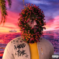 a man with flowers on his head in front of a beach