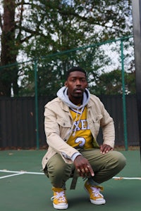 a man crouching down on a tennis court